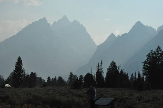 Lendo painel informativo sobre as imponentes montanhas do parque de Grand Teton, no Wyoming, nos Estados Unidos